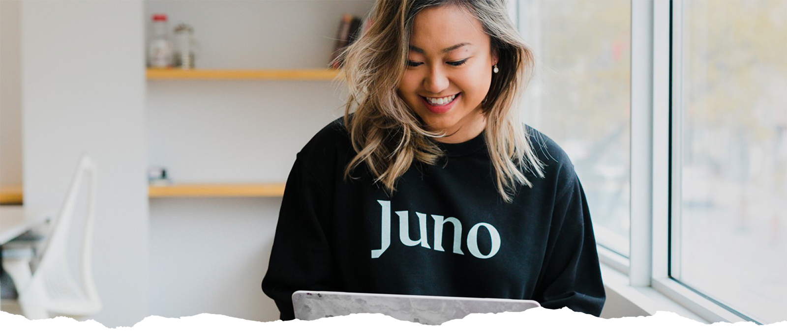 Young woman in Juno College branded sweatshirt learning at the Toronto campus